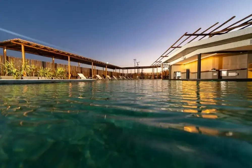 Piscina do Nanii ao entardecer com pérgolas de bambu